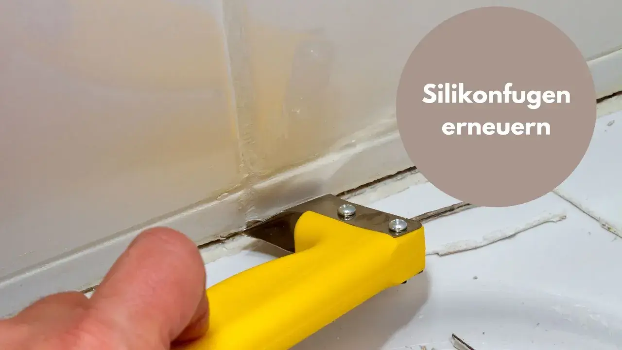 Mit einem gelben Werkzeug werden alte Silikonreste entfernt, um die Fugen zu erneuern.