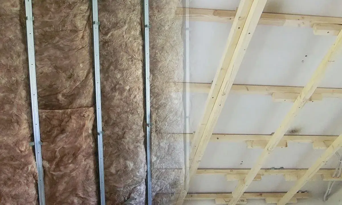 Isolierung in Metallständerwerk, bereit für das Kleben von Rigipsplatten. Decke mit Holzsparren und Dämmung.