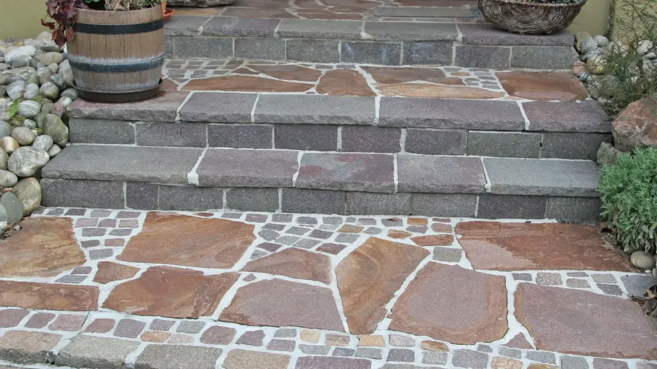 Stufen mit polygonalplatten verlegen. Große, unregelmäßige Steinplatten und kleine Pflastersteine bilden ein schönes Muster.
