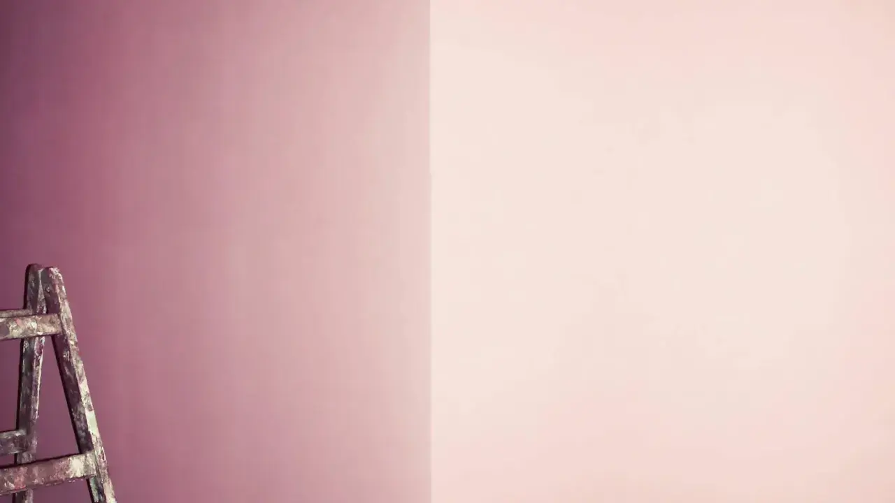 Alte Leiter steht vor einer Wand, die in zwei Rosatöne geteilt ist. Ein Projekt zum **Wandfarbe mischen**?