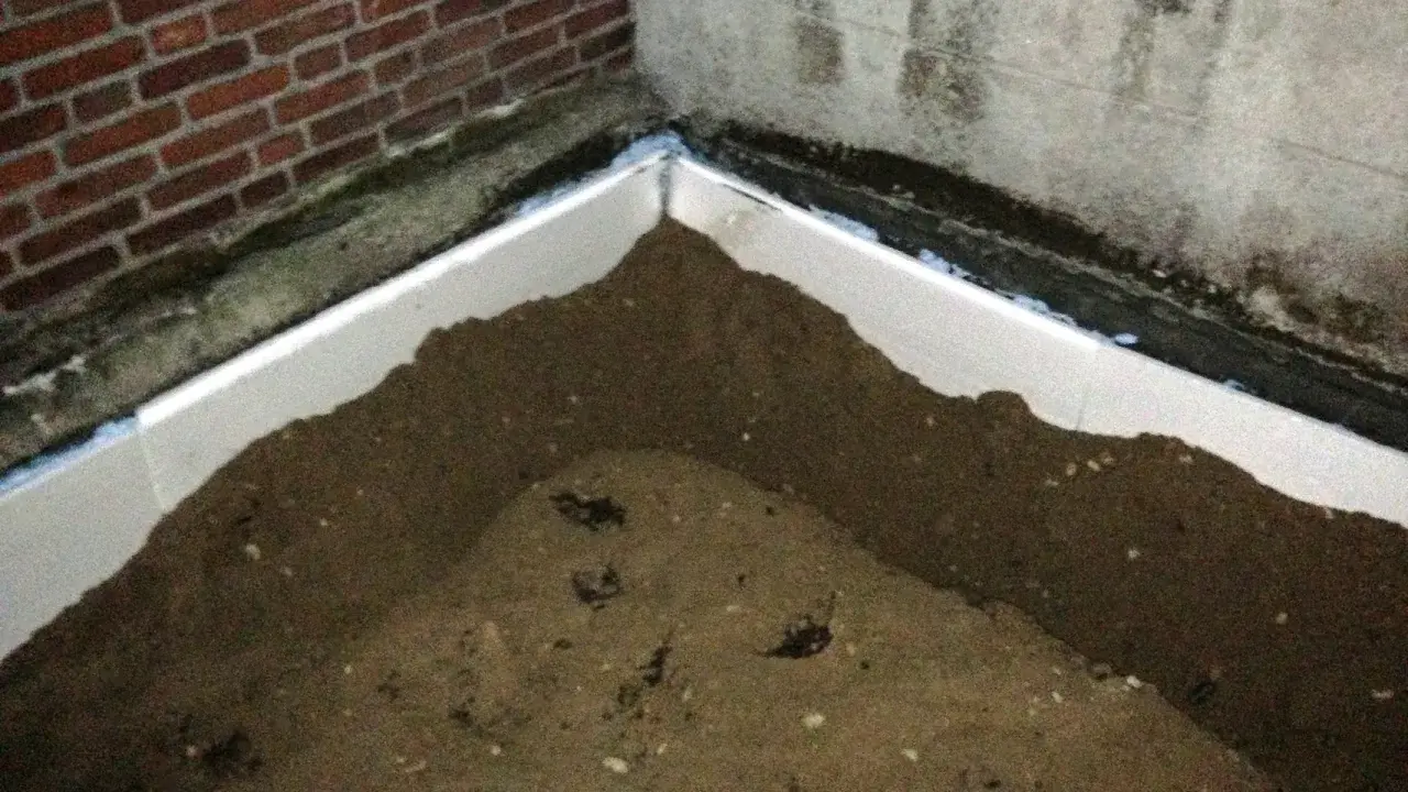Styrodurplatten werden auf Bitumen geklebt, um eine Dämmung zu schaffen. Sand liegt auf den Platten.