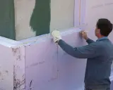 Mann markiert Styropor für Dämmung. Wichtig für Brandschutz und Wärmeschutz am Bau.