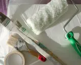 Pinsel, Farbroller und Klebeband liegen bereit. Die Frage "kann man Styropor streichen?" wird hier praktisch beantwortet.