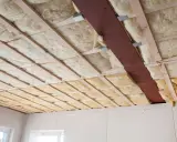 Holzlatten und eine Metallstrebe stützen die Dämmung. Glaswolle verarbeiten für eine gute Isolierung.