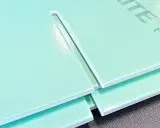Mehrere hellgrüne Hartschaumplatten liegen übereinander. Eine Platte zeigt eine gerade Schnittkante, die das Schneiden von Hartschaumplatten verdeutlicht.
