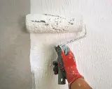 Mit einem speziellen Roller wird eine Strukturpaste aufgetragen, um eine interessante Wandgestaltung zu erzielen. Das Ergebnis erinnert an **Styropor spachteln** für eine einzigartige Textur.