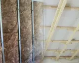 Isolierung in Metallständerwerk, bereit für das Kleben von Rigipsplatten. Decke mit Holzsparren und Dämmung.