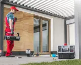 Handwerker mit Werkzeugkasten bereitet sich auf das vordach abdichten vor. Werkzeuge und Materialien liegen bereit.
