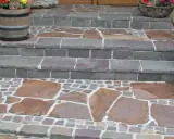 Stufen mit polygonalplatten verlegen. Große, unregelmäßige Steinplatten und kleine Pflastersteine bilden ein schönes Muster.
