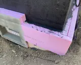 Dämmung wird angebracht. Pinke Styrodurplatten werden sorgfältig an die Wand geklebt, um das Gebäude zu isolieren.