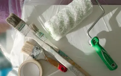 Pinsel, Farbroller und Klebeband liegen bereit. Die Frage "kann man Styropor streichen?" wird hier praktisch beantwortet.