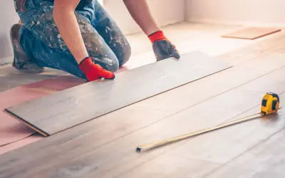 Handwerker verlegt Laminat. Eine Dehnungsfuge ist wichtig, damit sich das Holz ausdehnen kann.