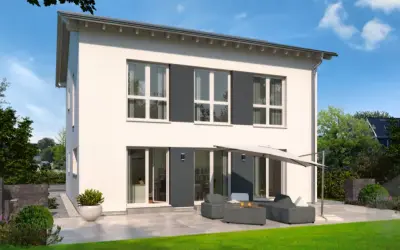 Moderne Stadtvilla mit Satteldach, großen Fenstern und einer gemütlichen Terrasse mit Lounge-Möbeln.