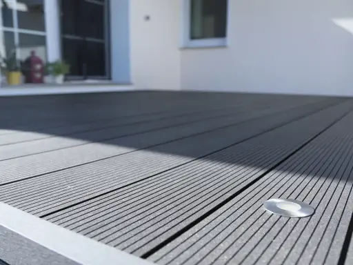 Moderne Terrasse mit grauen WPC Terrassendielen verlegen. Ein kleiner Bodenspot ist bereits integriert.