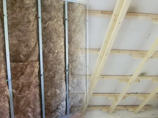Isolierung in Metallständerwerk, bereit für das Kleben von Rigipsplatten. Decke mit Holzsparren und Dämmung.