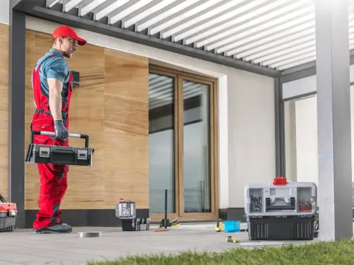 Handwerker mit Werkzeugkasten bereitet sich auf das vordach abdichten vor. Werkzeuge und Materialien liegen bereit.
