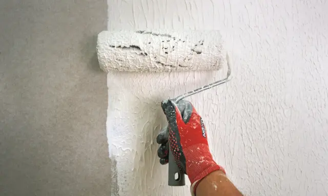 Mit einem speziellen Roller wird eine Strukturpaste aufgetragen, um eine interessante Wandgestaltung zu erzielen. Das Ergebnis erinnert an **Styropor spachteln** für eine einzigartige Textur.