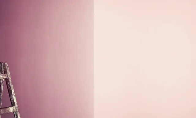 Alte Leiter steht vor einer Wand, die in zwei Rosatöne geteilt ist. Ein Projekt zum **Wandfarbe mischen**?