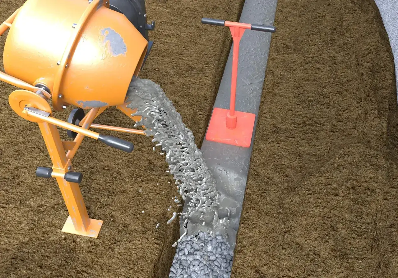 Betonmischer kippt fl&uuml;ssigen Zement in eine vorbereitete Grube mit Kies. Ein Stampfer liegt daneben, bereit, die Masse f&uuml;r das Randsteine setzen zu verdichten.