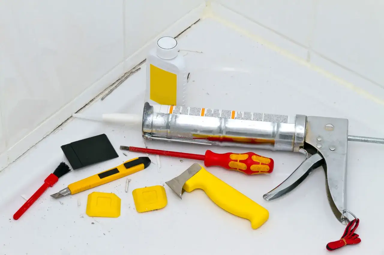 Werkzeuge zum Entfernen von Silikonresten: Kartuschenpresse, Messer, Spachtel, B&uuml;rste und Flasche.