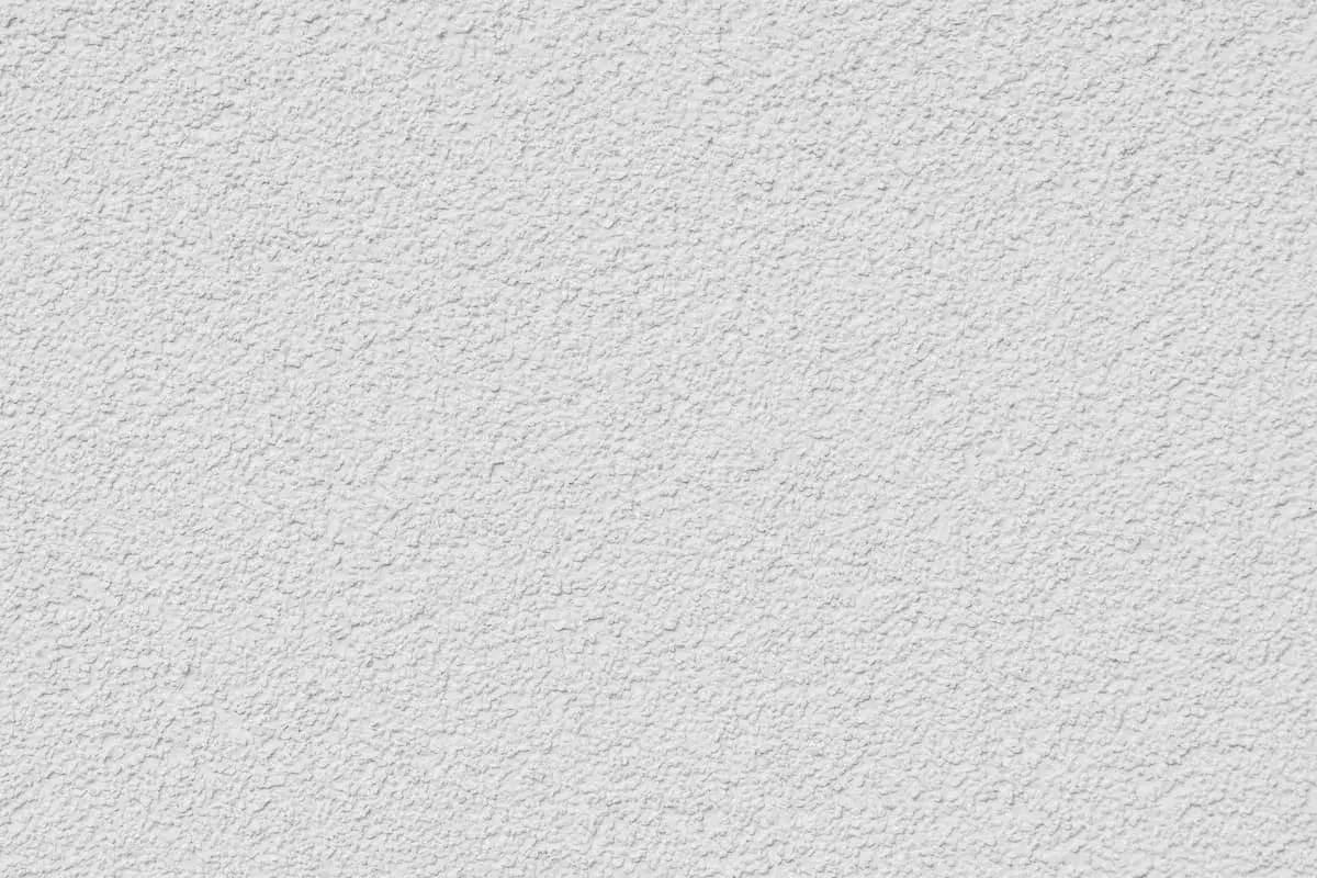 Eine wei&szlig;e Wand mit einer strukturierten Oberfl&auml;che, die das Ergebnis von Rollputz auftragen ist.