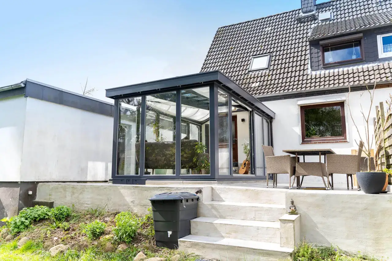 Moderner Wintergarten mit Glasfront, der zum Entspannen einlädt. Informieren Sie sich über die Wintergarten Kosten für Ihr Traumhaus.