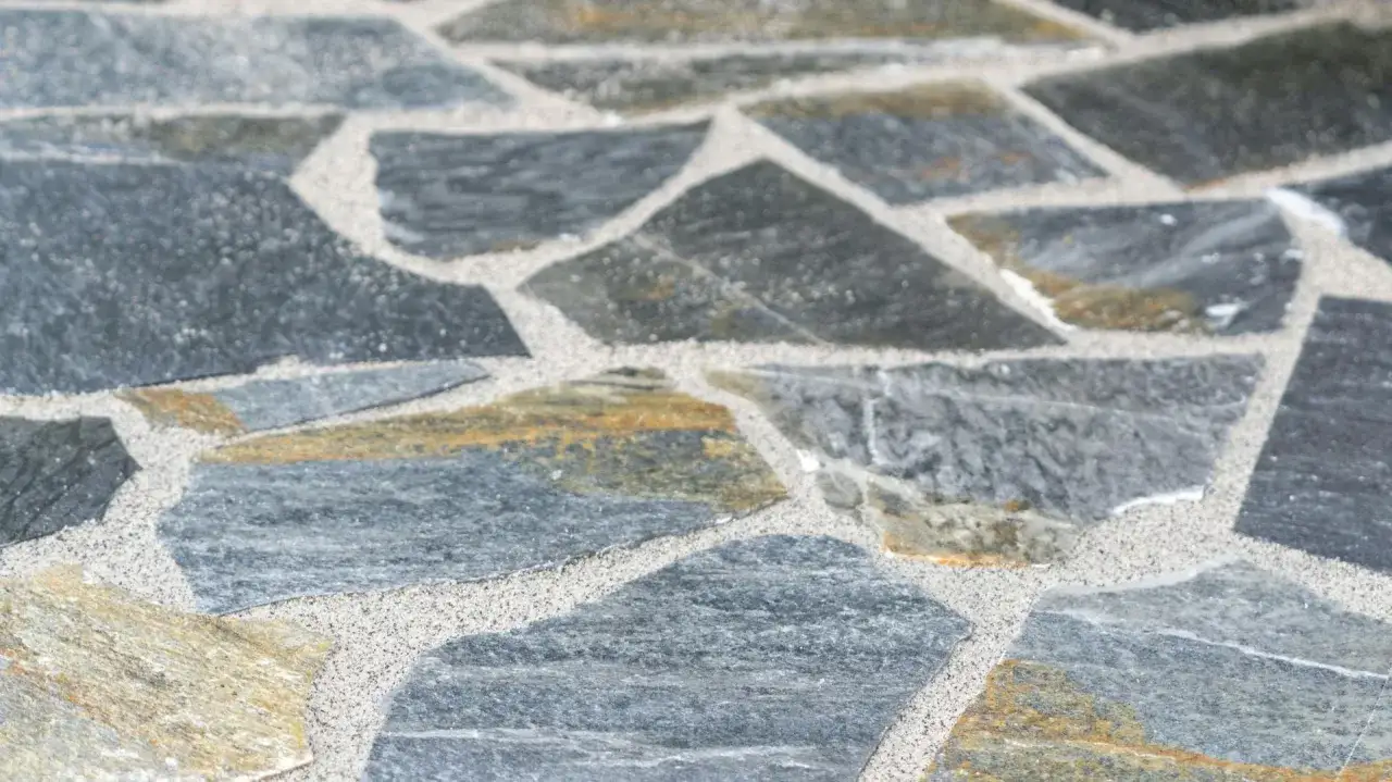 Detailaufnahme von polygonalplatten verlegen. Graue und gelbliche Steine mit hellem Fugenm&ouml;rtel.
