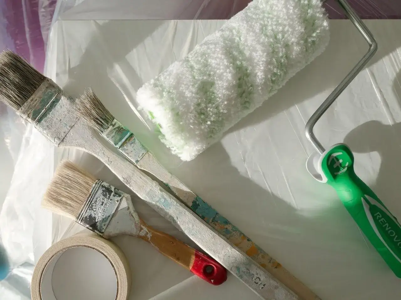 Pinsel, Farbrolle und Klebeband liegen bereit. Die Frage ist: kann man Styropor streichen? Ja, mit den richtigen Werkzeugen und Farben ist das möglich.