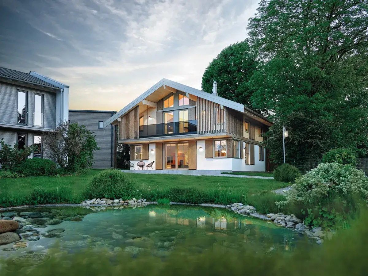 Moderne haus stile mit Holzfassade und großem Teich. Ein Haus mit viel Glas und einem spitzen Dach.