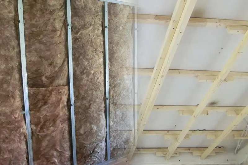 Isolierung in Metallständerwerk, bereit für das Kleben von Rigipsplatten. Decke mit Holzsparren und Dämmung.